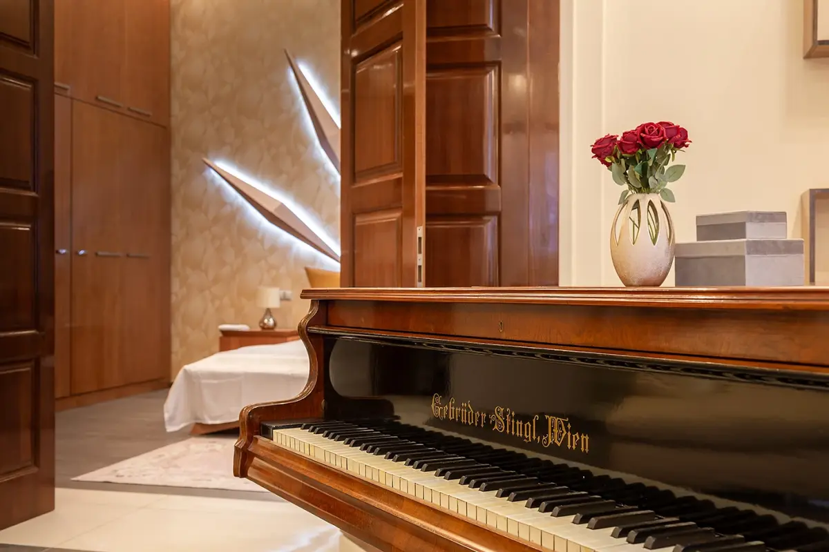 A grand piano with red roses in the piano salon