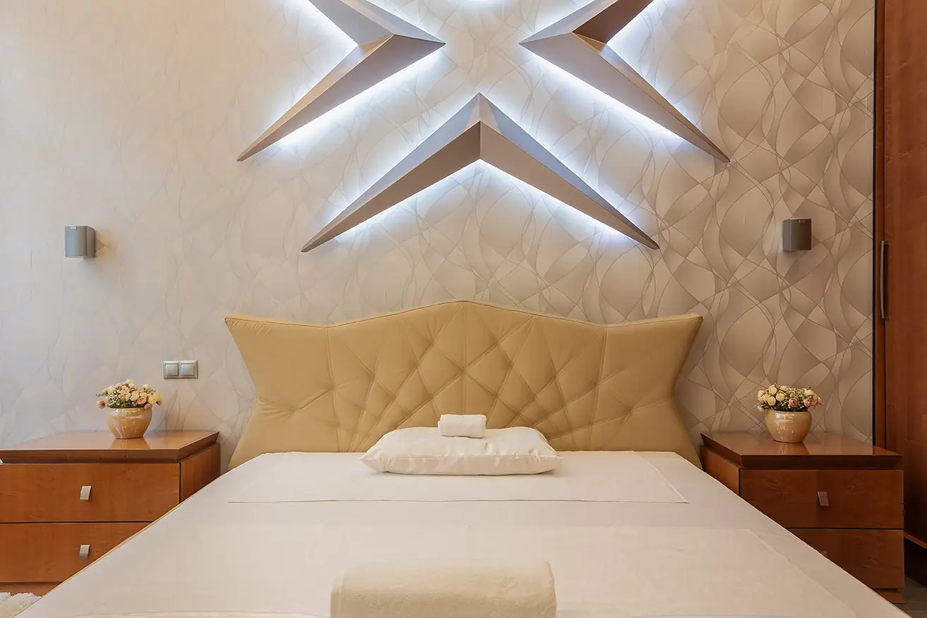 Suite with a lit star-shaped headboard and a made bed